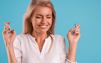 young female crossing fingers on both hands and smiling